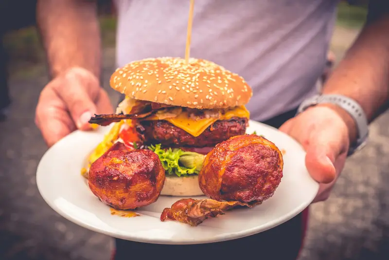 Burger mit Beilagen auf einem Teller