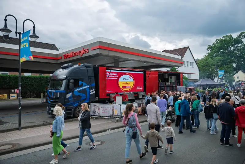 Gäste vor dem beleuchteten Gastro-Liner am Abend