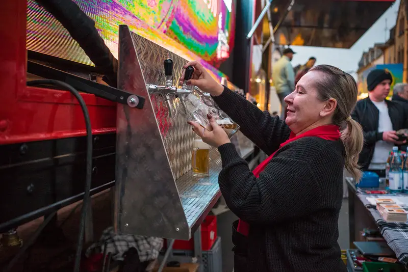Servicekraft zapft frisches Bier an der Theke